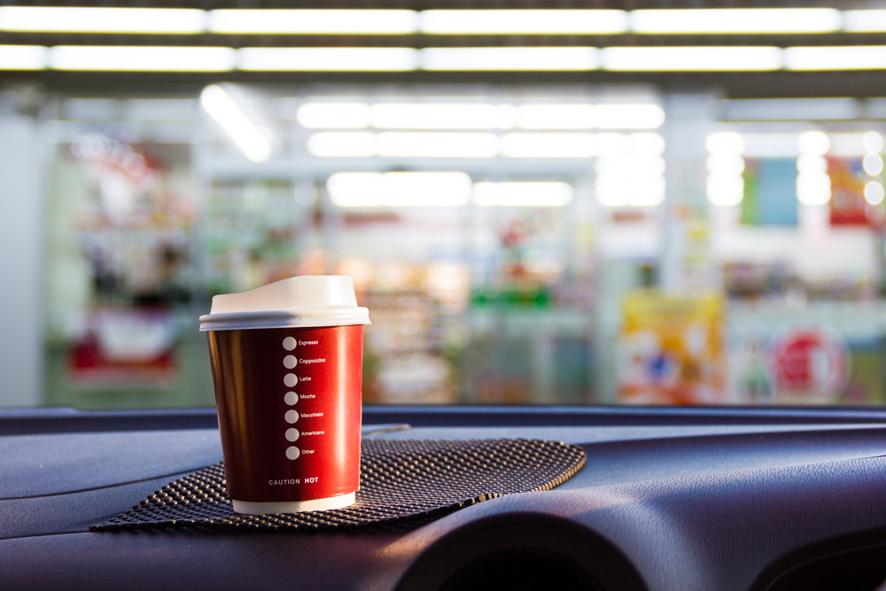 convenience store coffee sitting on car dashboard